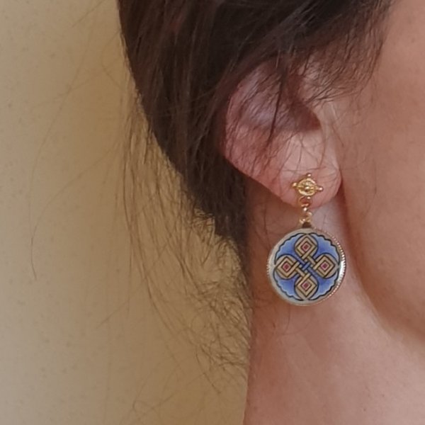 Verlichte oorbellen met rode of blauwe palmetten en gouden vlechtwerk