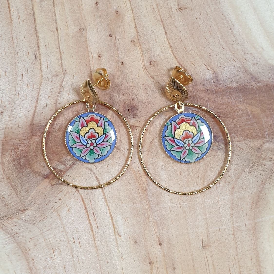 Oosterse bloem hanger oorbellen met blauwe achtergrond
