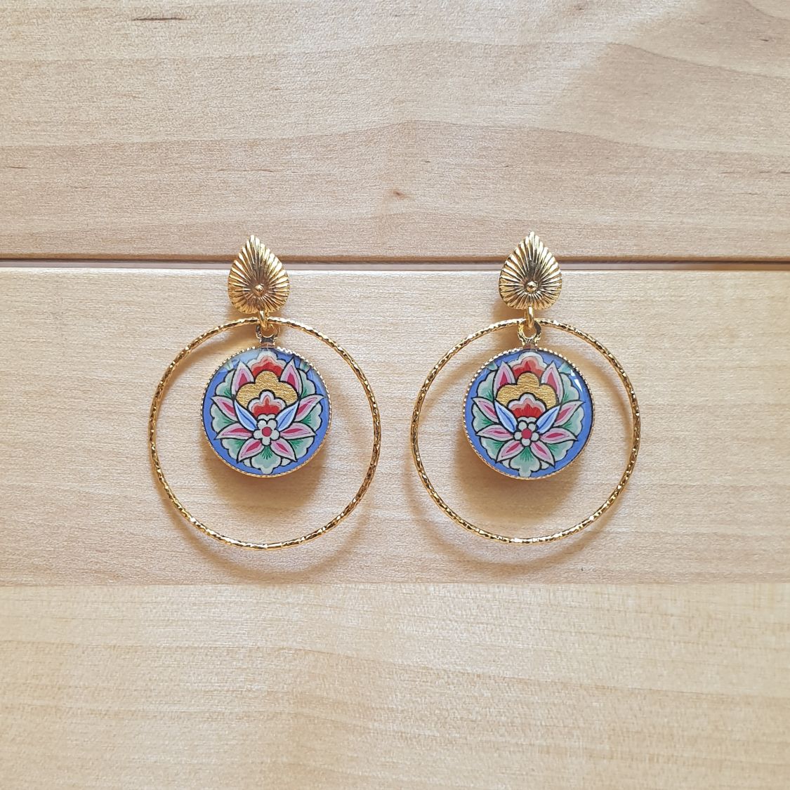 Oosterse bloem hanger oorbellen met blauwe achtergrond