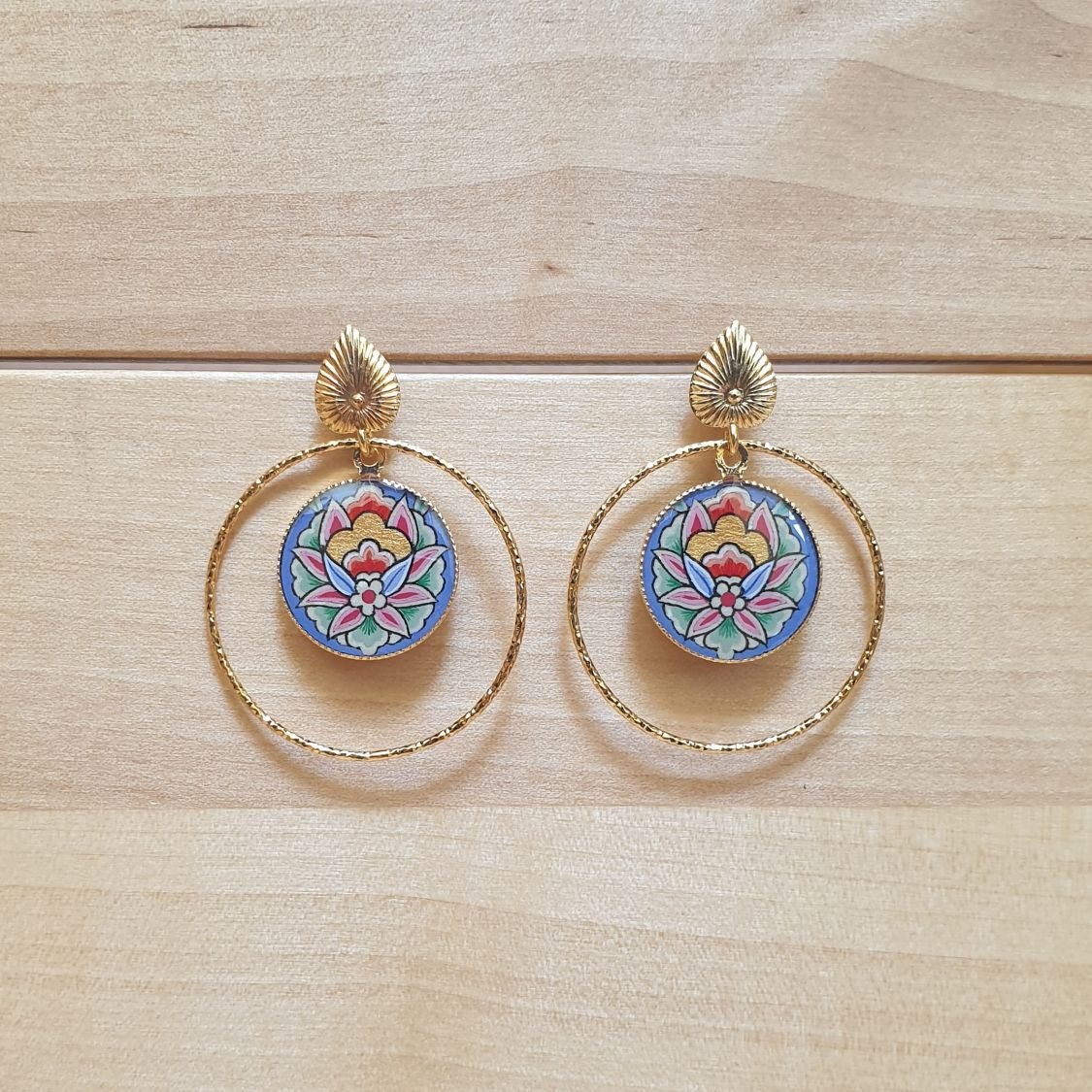 Oosterse bloem hanger oorbellen met blauwe achtergrond