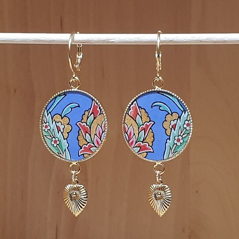 Oosterse bloem hanger oorbellen met blauwe achtergrond