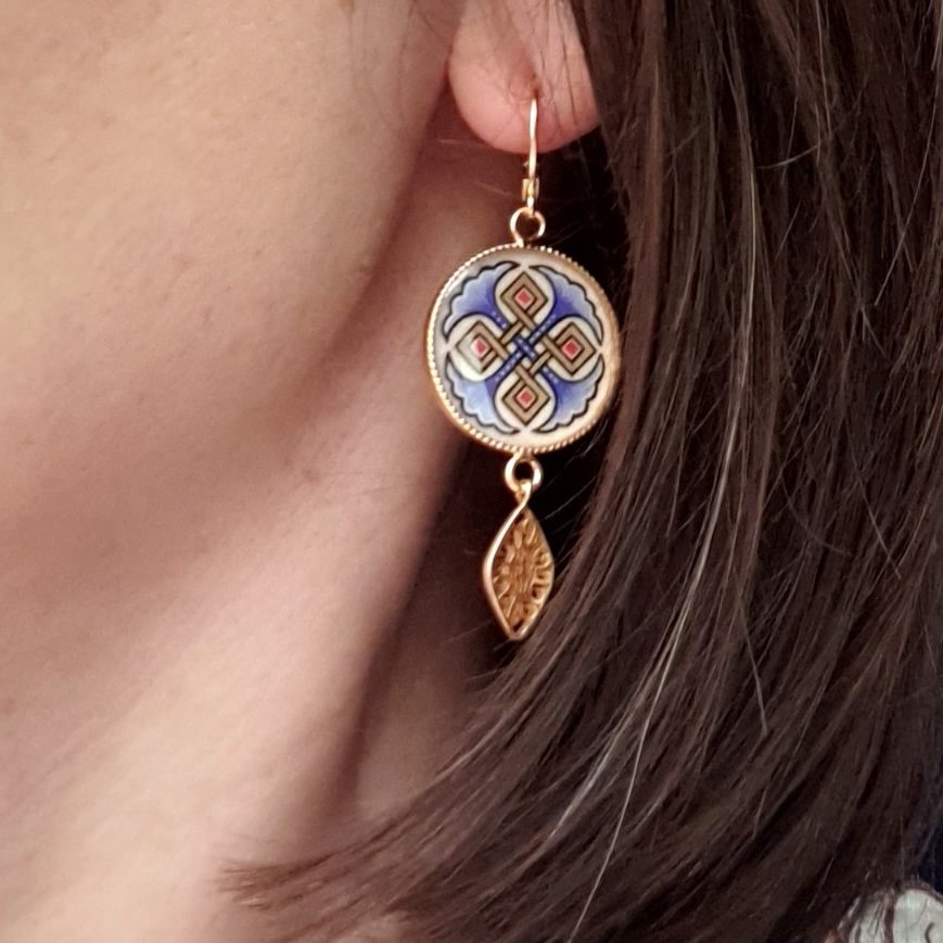 Rode of blauwe palmetten en gouden hanger oorbellen.