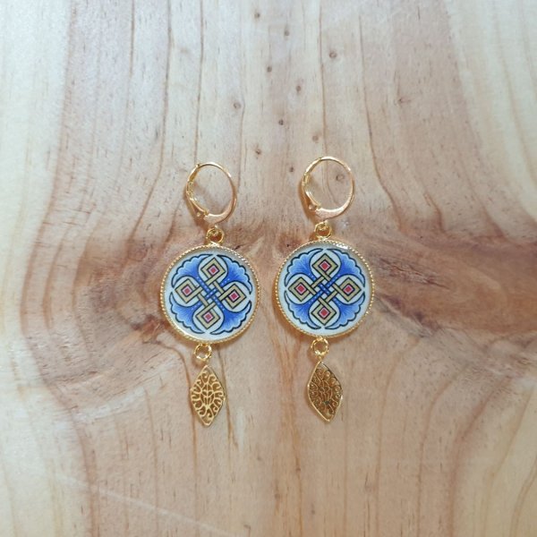Rode of blauwe palmetten en gouden hanger oorbellen.