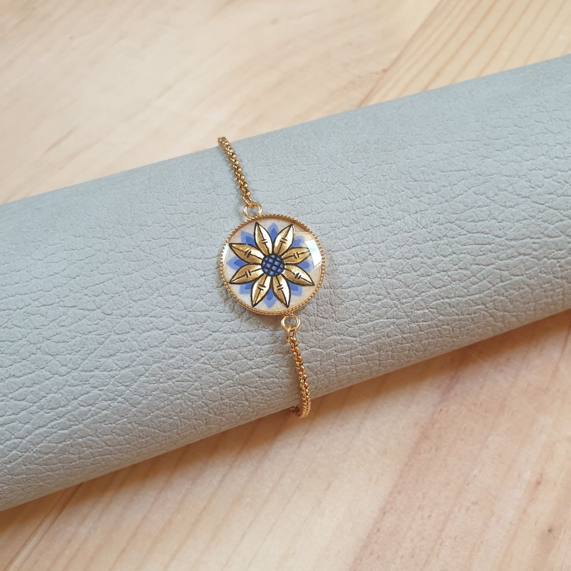 Verstelbare armband met goud/blauw bloemmotief aan gouden ketting