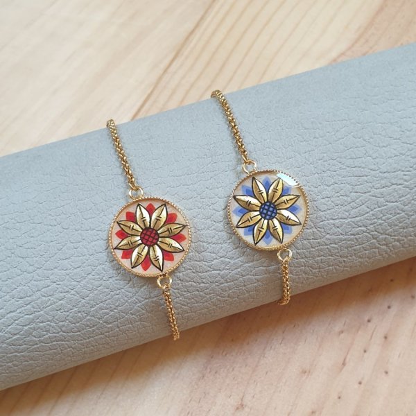 Verstelbare armband met goud/blauw bloemmotief aan gouden ketting