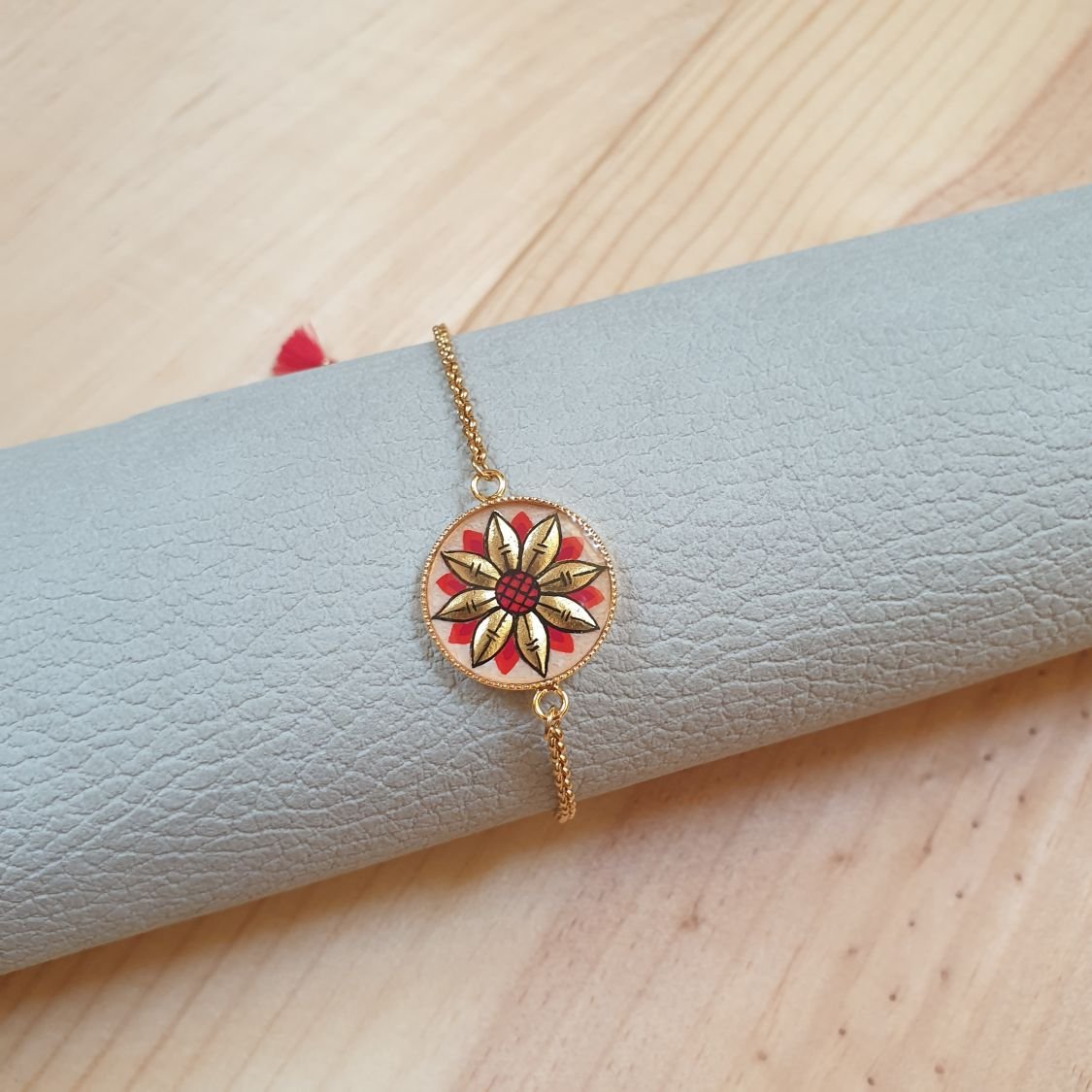 Verstelbare armband met goud/blauw bloemmotief aan gouden ketting