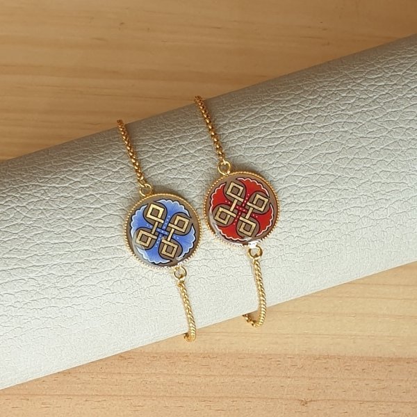 Bracelet r&eacute;glable entrelacs or et palmettes rouges ou bleues