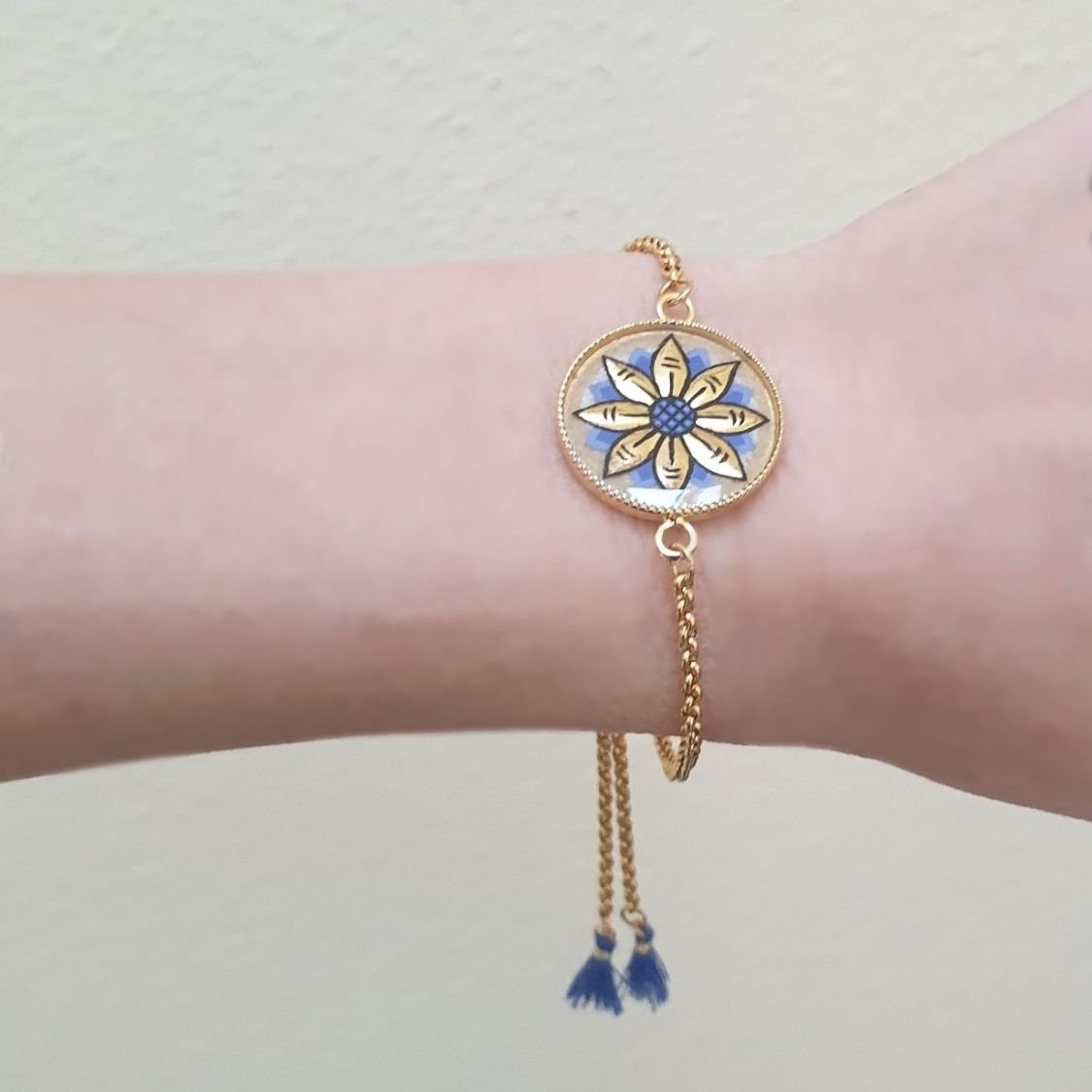 Verstelbare armband met goud/blauw bloemmotief aan gouden ketting