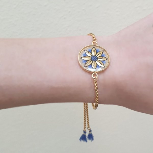 Verstelbare armband met goud/blauw bloemmotief aan gouden ketting