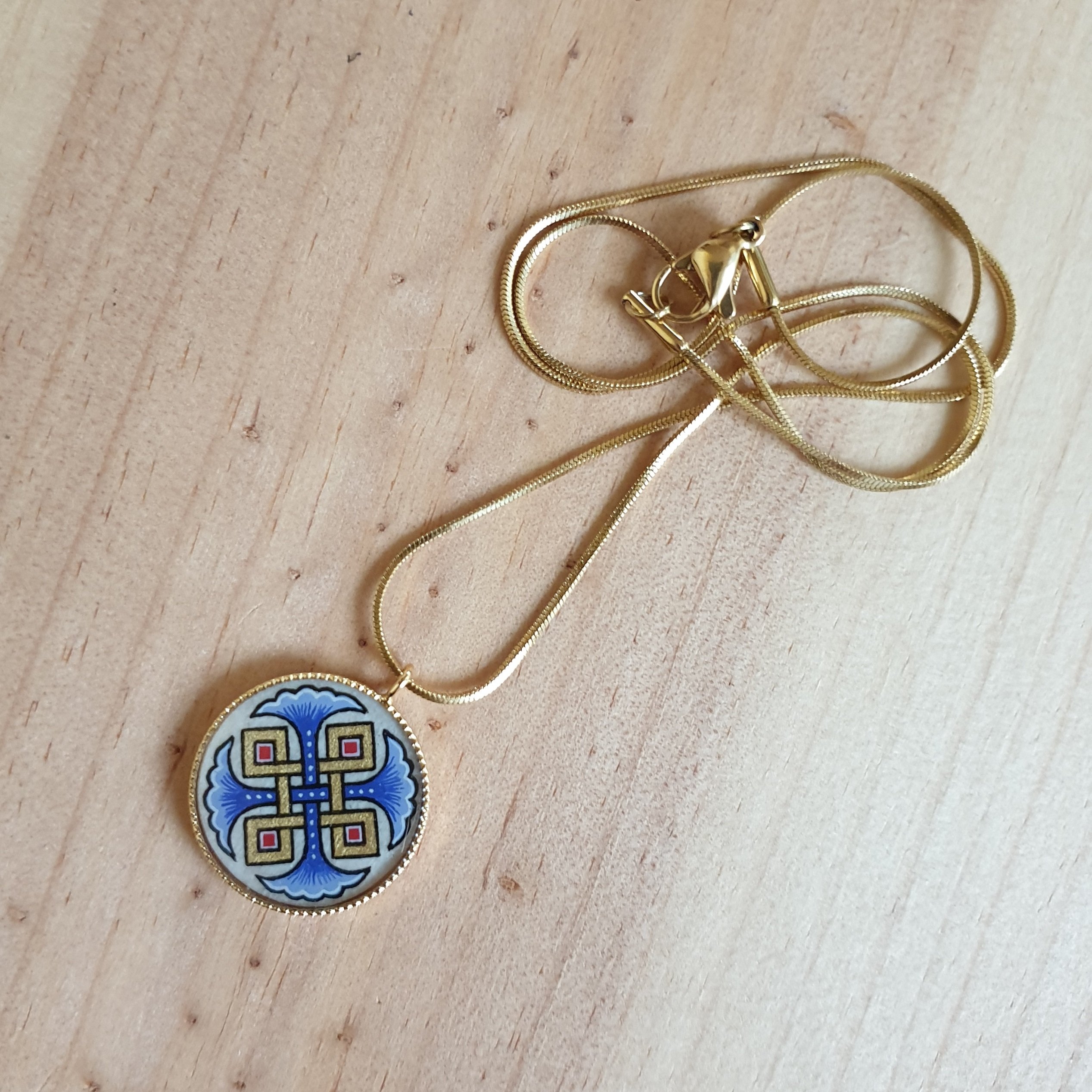 Hanger collier met blauwe palmetten, goud en rood vlechtwerk aan gouden ketting