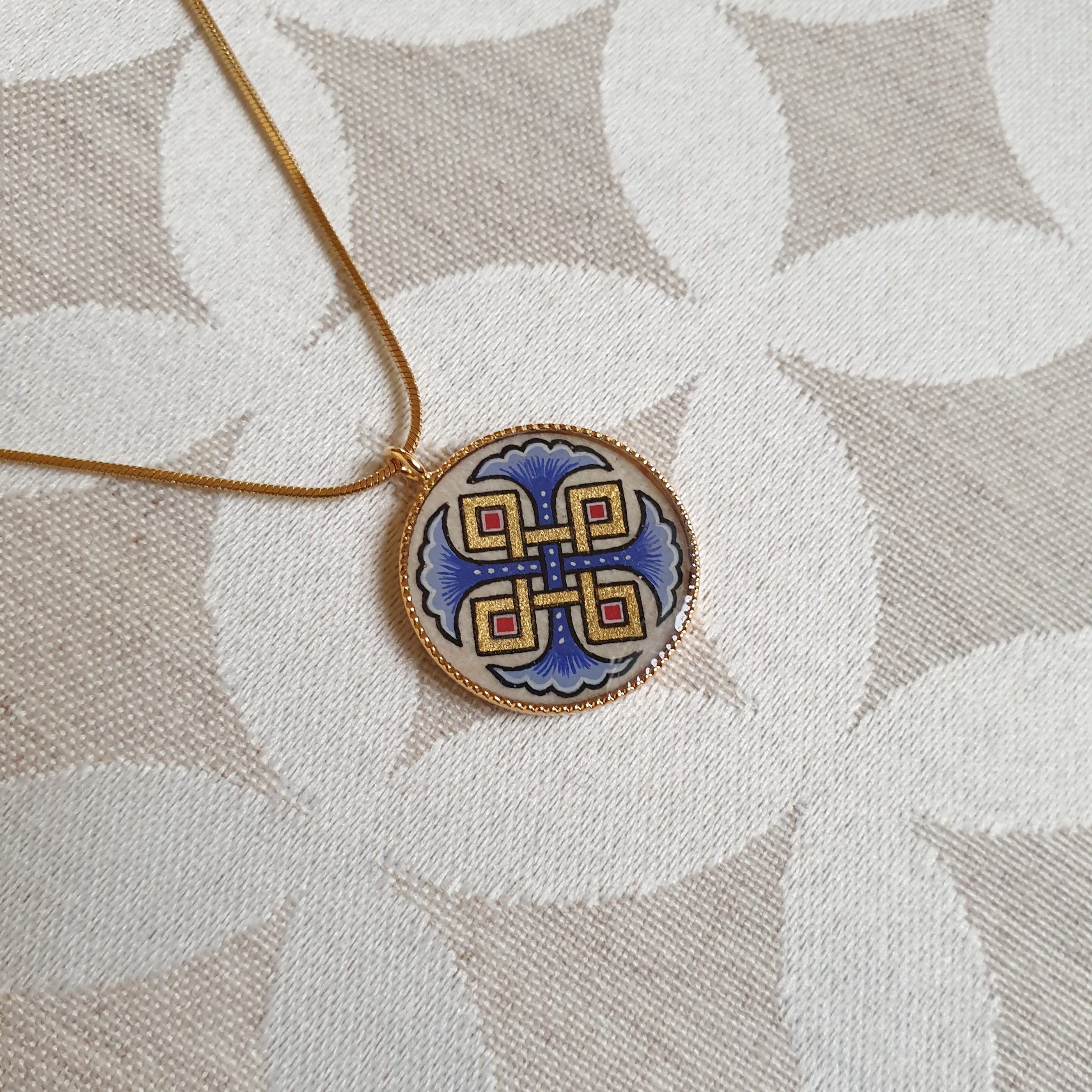 Hanger collier met blauwe palmetten, goud en rood vlechtwerk aan gouden ketting