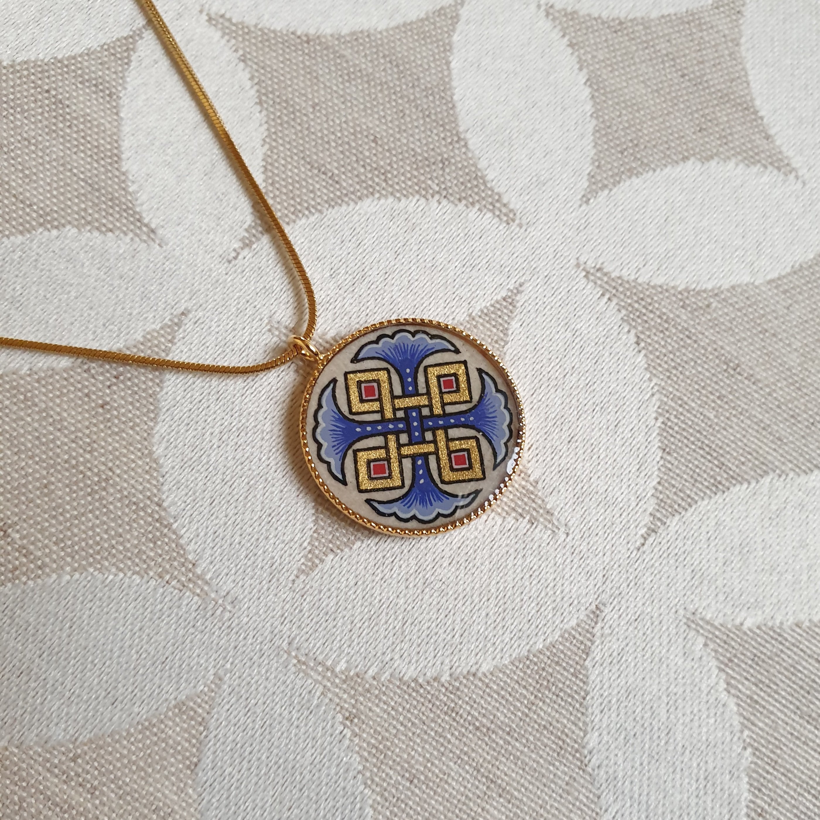 Hanger collier met blauwe palmetten, goud en rood vlechtwerk aan gouden ketting